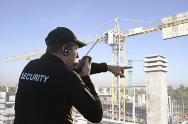 A security guard speaking on a walkie-talkie